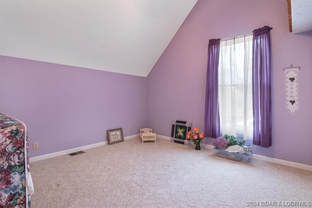 interior space featuring light carpet and vaulted ceiling