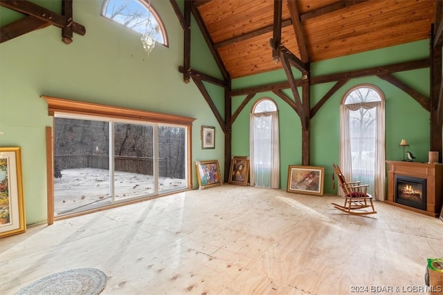 unfurnished living room with high vaulted ceiling, wood ceiling, and beamed ceiling