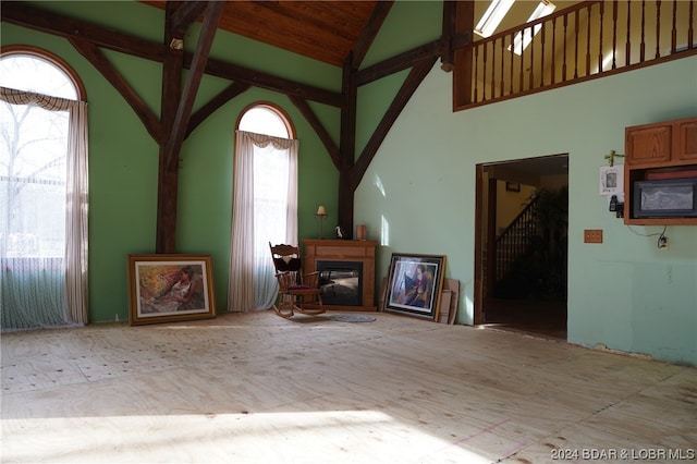 unfurnished living room featuring high vaulted ceiling