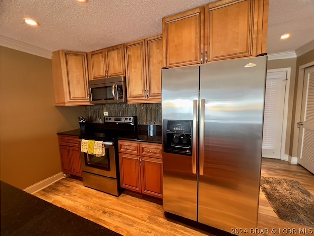 kitchen featuring a textured ceiling, stainless steel appliances, crown molding, and tasteful backsplash