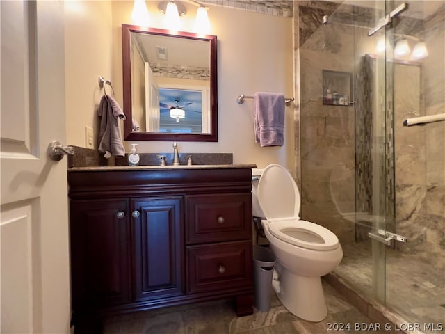 bathroom with toilet, vanity, and a shower with shower door