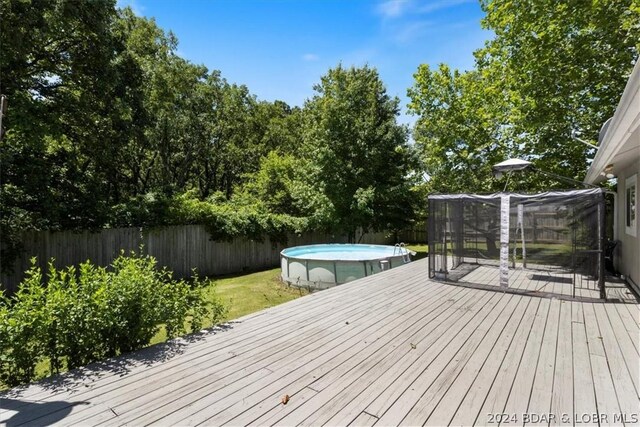 wooden terrace with a fenced in pool