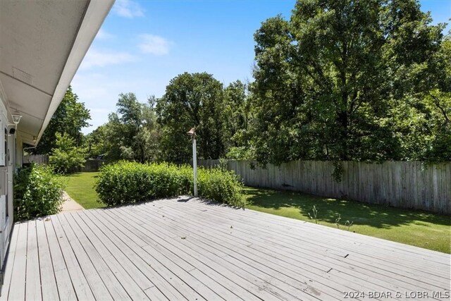 wooden terrace featuring a yard