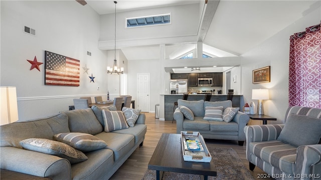 living room featuring beamed ceiling, dark wood-type flooring, high vaulted ceiling, and a notable chandelier