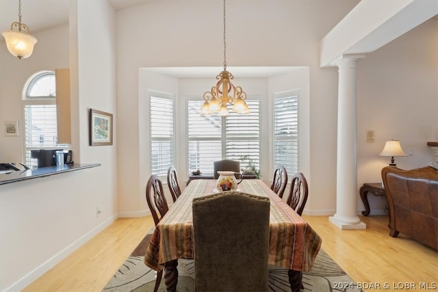 dining space with a healthy amount of sunlight, decorative columns, and light wood-type flooring