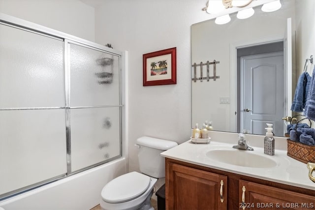 full bathroom with toilet, bath / shower combo with glass door, and vanity