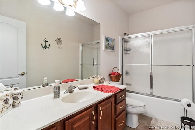 full bathroom featuring toilet, tile floors, vanity, and enclosed tub / shower combo