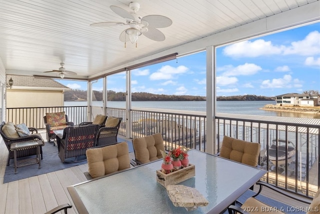 sunroom / solarium with a water view and ceiling fan