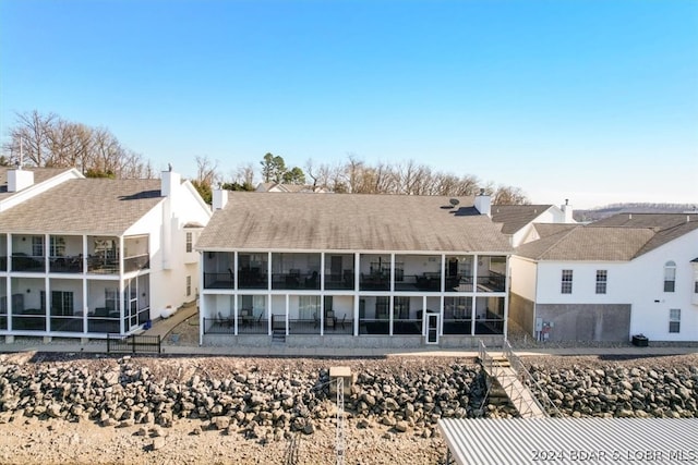 rear view of property with a sunroom and a patio