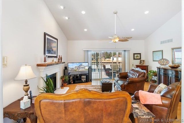 living room with light hardwood / wood-style flooring, ceiling fan, and high vaulted ceiling