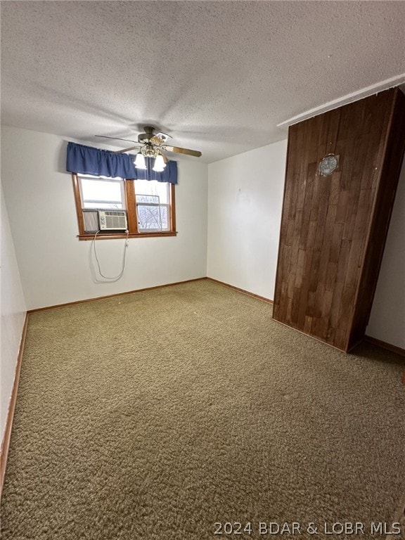 carpeted spare room featuring ceiling fan and a textured ceiling