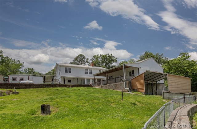 rear view of property featuring a yard and a carport