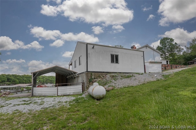 view of home's exterior featuring a carport and a lawn