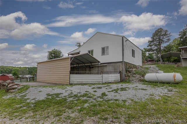 view of property exterior with a carport and an outdoor structure