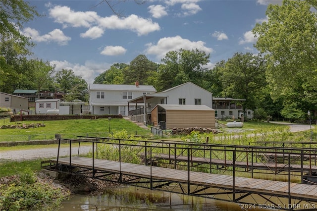 rear view of property with a lawn and a water view