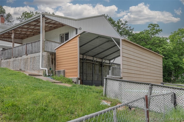 view of side of property featuring a lawn and a carport