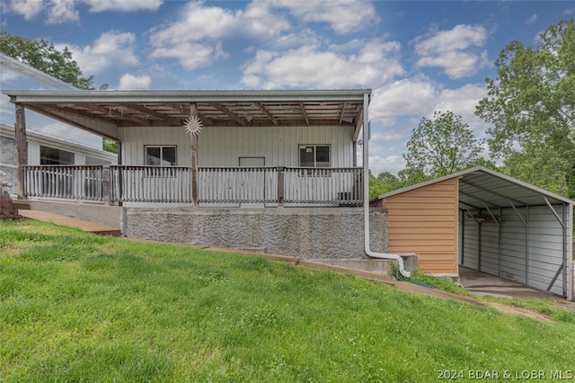 back of property featuring a carport and a lawn