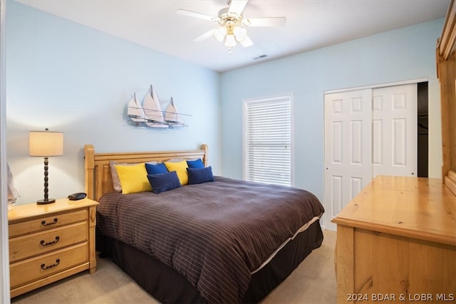 carpeted bedroom with ceiling fan and a closet