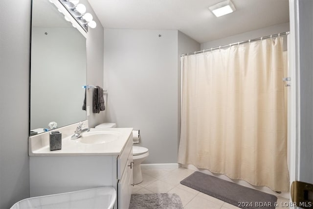 bathroom featuring toilet, vanity with extensive cabinet space, and tile flooring