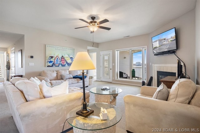 living room with light carpet, ceiling fan, and a fireplace