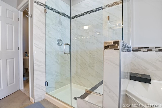 bathroom featuring toilet, separate shower and tub, and tile walls