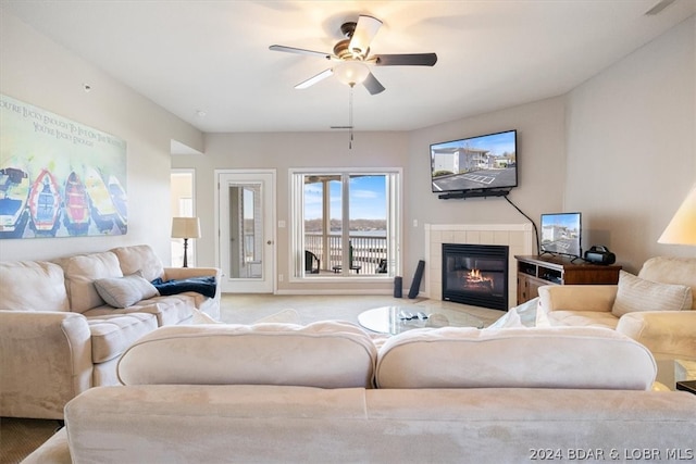 living room featuring ceiling fan and a tile fireplace