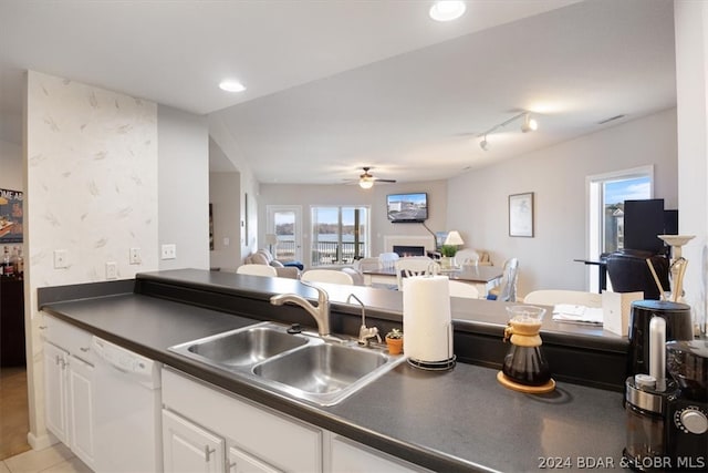 kitchen with ceiling fan, sink, white dishwasher, rail lighting, and white cabinets