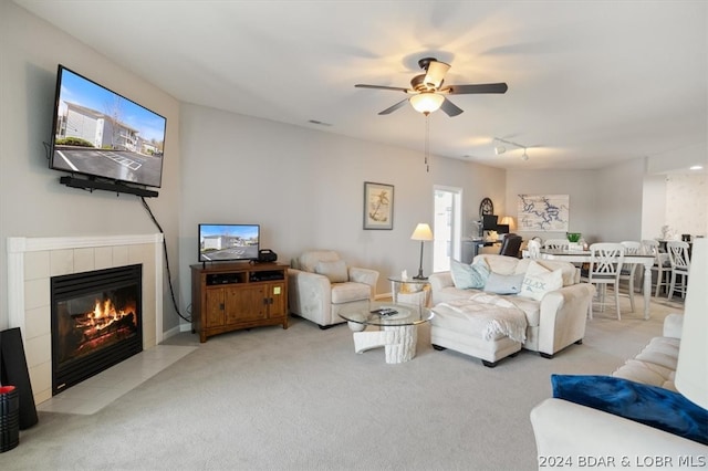 carpeted living room featuring ceiling fan and a fireplace