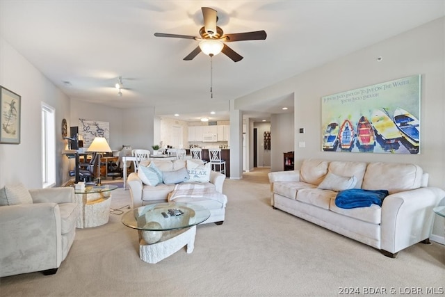 carpeted living room with ceiling fan