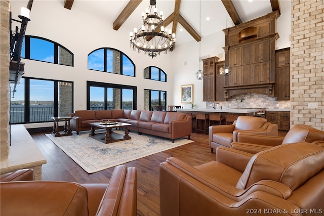 living room featuring an inviting chandelier, dark wood-type flooring, beam ceiling, and high vaulted ceiling