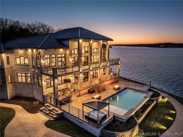 dock area with a water view, a balcony, and a patio