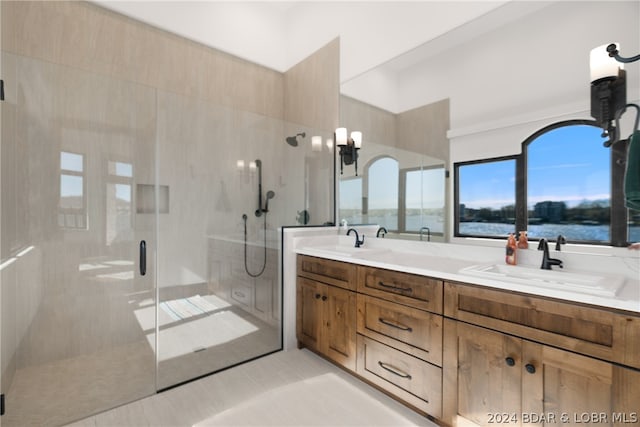 bathroom featuring walk in shower, a water view, tile floors, and double sink vanity