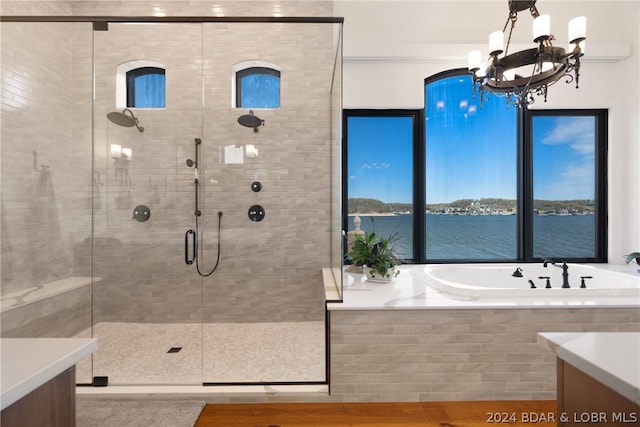 bathroom with a water view, plus walk in shower, a notable chandelier, and vanity