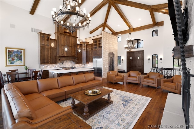 living room with high vaulted ceiling, dark hardwood / wood-style flooring, and an inviting chandelier