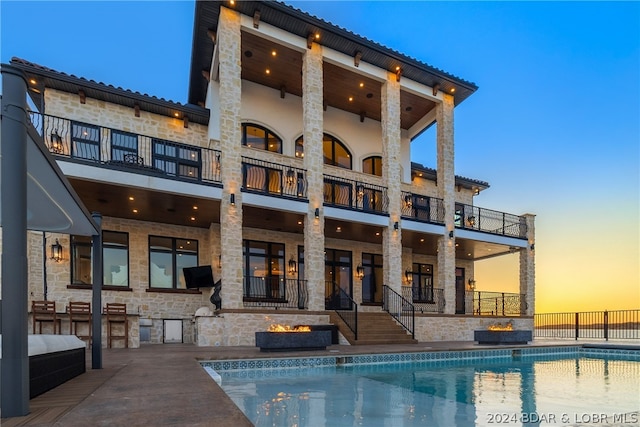 pool at dusk featuring a patio