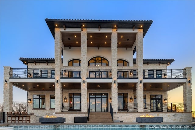 back house at dusk with a balcony