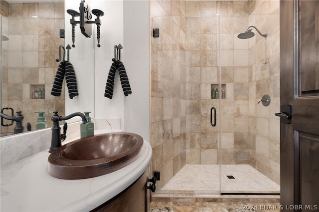 bathroom featuring a shower with door and vanity with extensive cabinet space