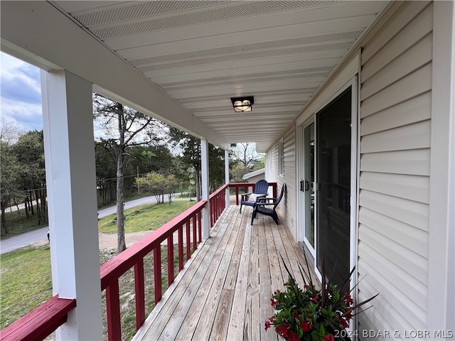 wooden terrace featuring a lawn