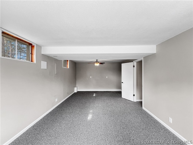 empty room with ceiling fan and a textured ceiling