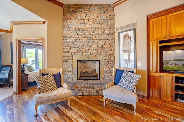 sitting room with crown molding, hardwood / wood-style floors, and a fireplace