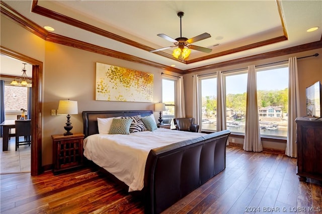 bedroom featuring crown molding, dark hardwood / wood-style floors, and a raised ceiling