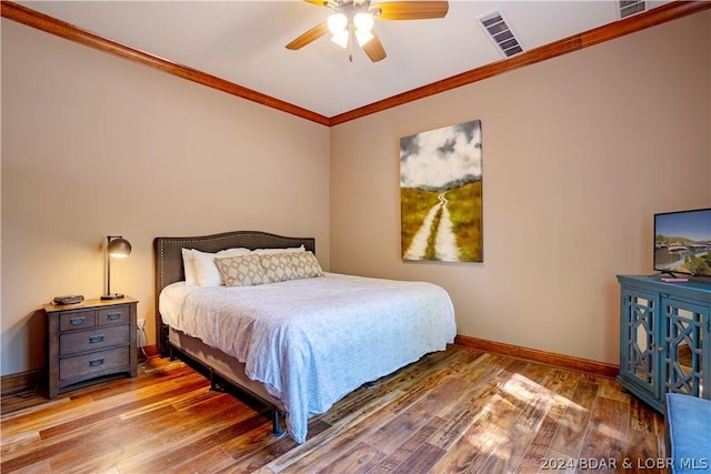 bedroom featuring ceiling fan, ornamental molding, and wood-type flooring