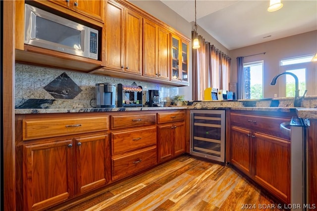 kitchen featuring tasteful backsplash, stainless steel microwave, wine cooler, and dark stone counters