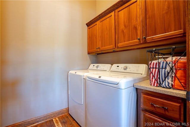 clothes washing area with cabinets, dark hardwood / wood-style flooring, and independent washer and dryer