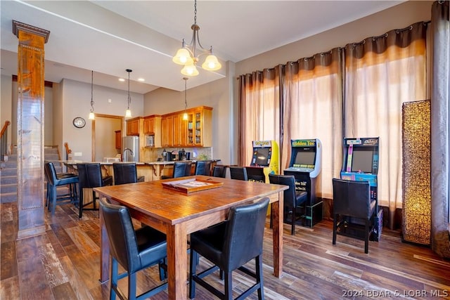 dining space with dark hardwood / wood-style floors and a notable chandelier