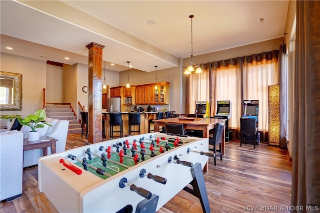 recreation room with hardwood / wood-style floors and ornate columns