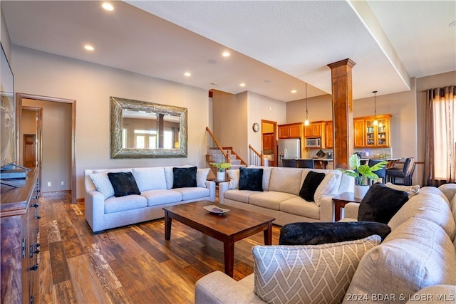 living room featuring dark hardwood / wood-style flooring and ornate columns