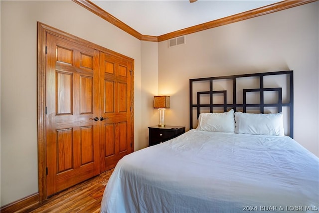 bedroom featuring crown molding and light wood-type flooring