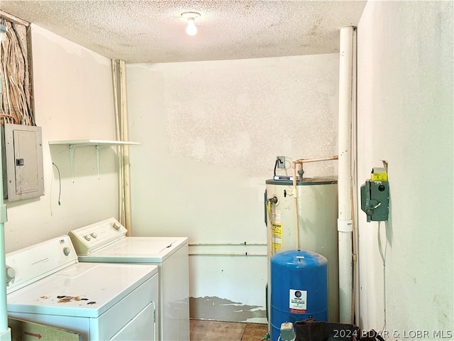 clothes washing area with a textured ceiling, electric panel, and washing machine and clothes dryer