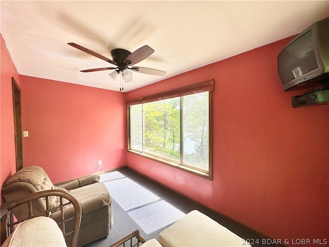 living room featuring ceiling fan and carpet